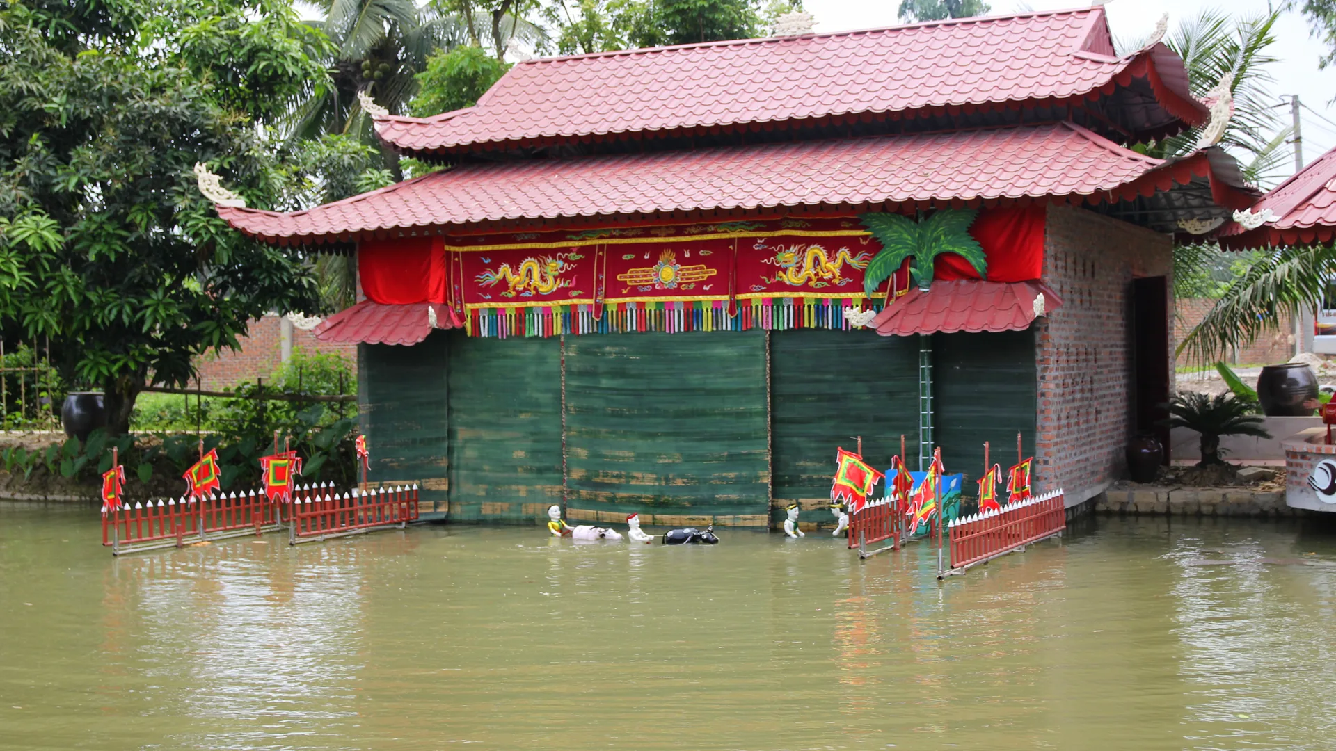 Brightly painted Vietnamese water puppets performing on a pool of water